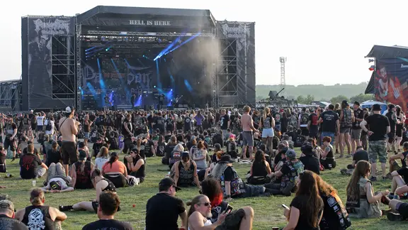 Besucher eines Metalfestivals vor einer Bühne.
