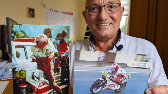 Michael Freudenberg zeigt historische Fotos, die ihn als Motorsportler zeigen. 