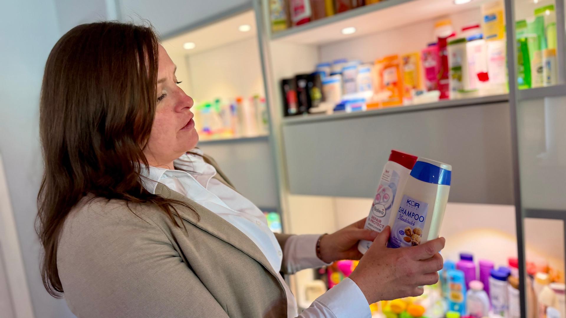 Eine Frau hält zwei Shampooflaschen. | MDR/Bettina Ehrlich