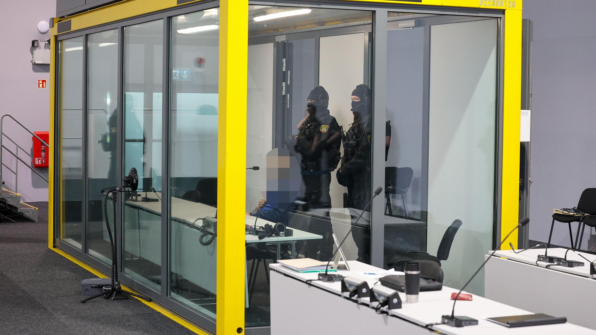 Gerichtssaal: Angeklagter ist verpixelt, zwei Polizeiwachen hinter ihm. | dpa | Peter Gercke