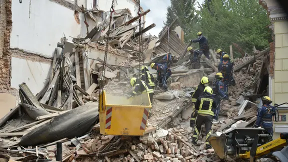 Rettungskräfte von Feuerwehr und THW wühlen sich nach dem Einsturz eines Hauses durch den Schutt. 