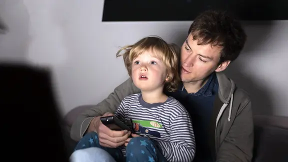 Ein Vater und sein Kleinkind schauen fern.