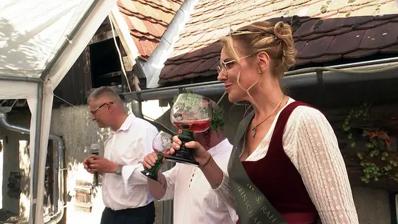 Junge Frau mit Schärpe und Weinpokal