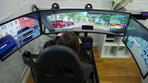 Eine Frau sitzt im Fahrsimulator.