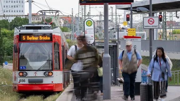 Fahrgäste einer Straßenbahn steigen am Morgen zu Beginn des Berufsverkehrs am Hauptbahnhof in Halle/Saale aus.