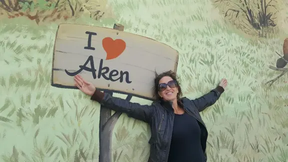 Christine Koschmieder vor einem Wandbild mit der Aufschrift "I love Aken".
